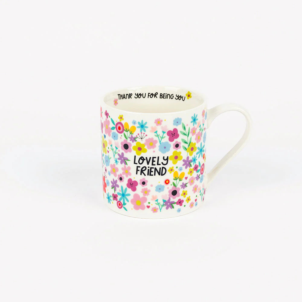 White ceramic mug with colorful floral pattern and the words “Lovely Friend” on the front, and the phrase “Thank you for being you” printed inside the rim.