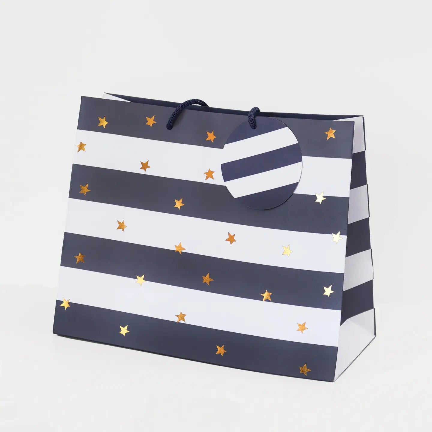 Gift bag with navy stripes and gold stars on a white background