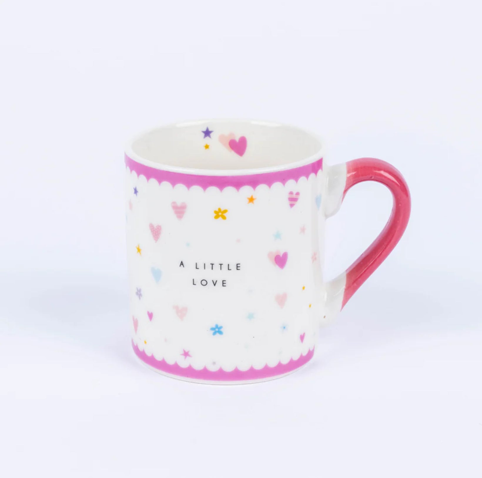 A white china mug with pink accents and multicolored design, featuring the text 'A LITTLE LOVE' and various shapes like hearts and stars.