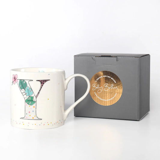 A white china mug with a colorful floral and insect design, featuring the monogram initial 'Y', and a grey presentation box with 'Belly Button Designs' branded on it.