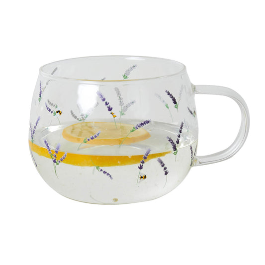 A clear glass mug with purple floral patterns and a handle on the right side, displaying a lemon slice and lavender buds inside.