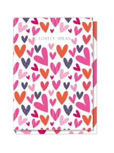 A5 hardback notebook with a colorful cover featuring a pattern of big hearts in pink, orange, and purple shades.