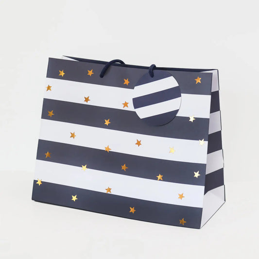 Gift bag with navy stripes and gold stars on a white background