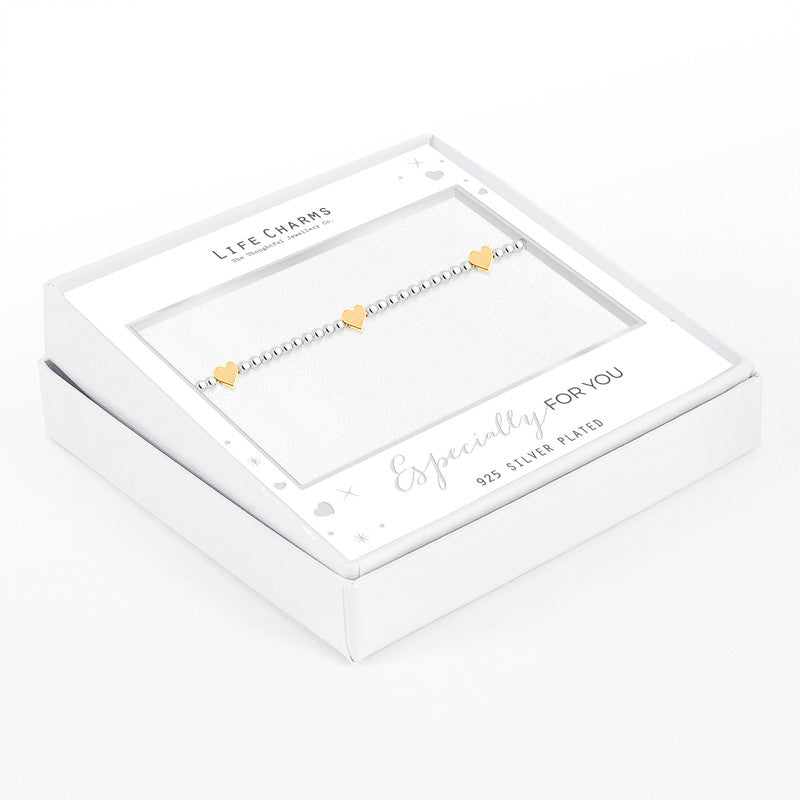 A silver bracelet with small heart charms, presented in a white box with 'Life Charms' branding.