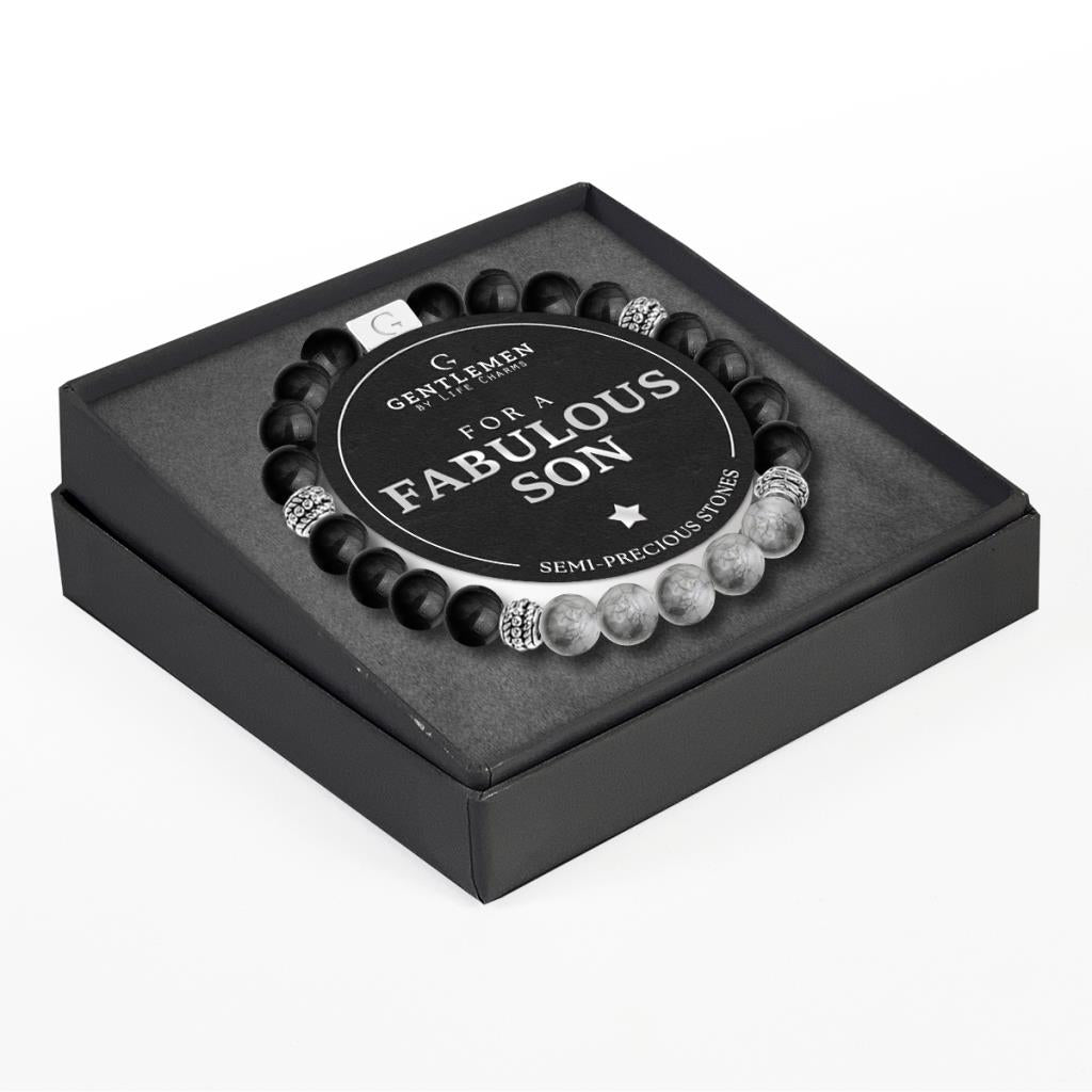 An elastic bracelet with black and white beads, featuring an elegant tear drop pendant, presented in a square black box with a birthday message for a son.