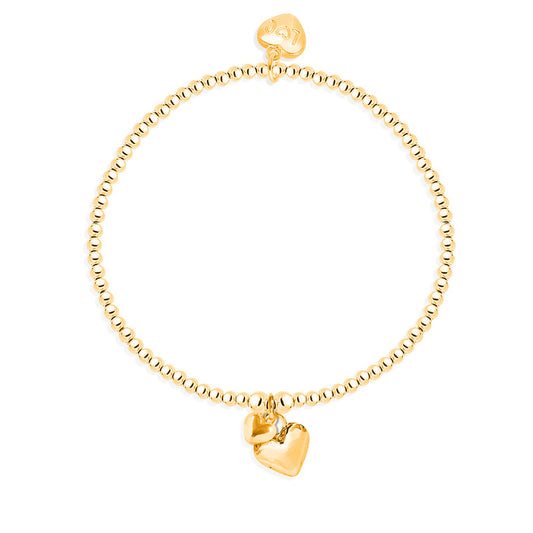 A gold-colored bracelet with a series of puffed heart charms of varying sizes attached to it, displayed against a white background.