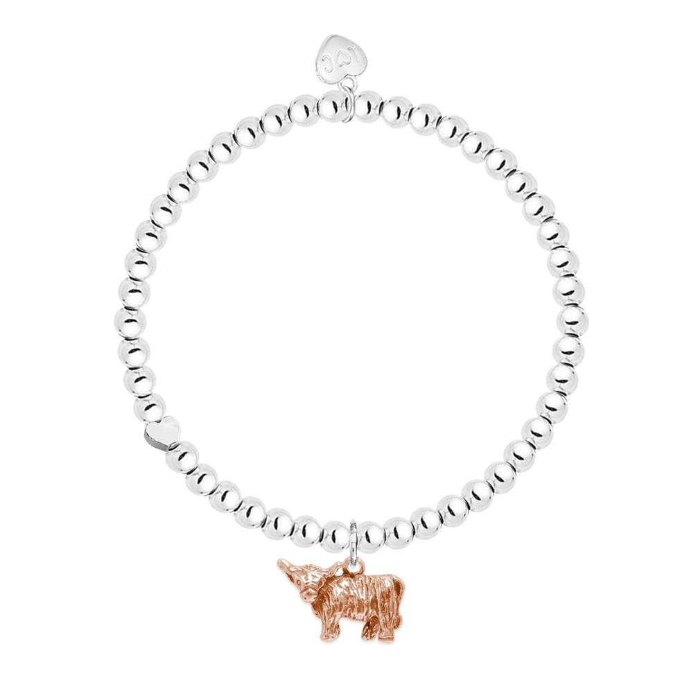 A rose gold plated highland cow charm on a bracelet with silver beaded stretch band.
