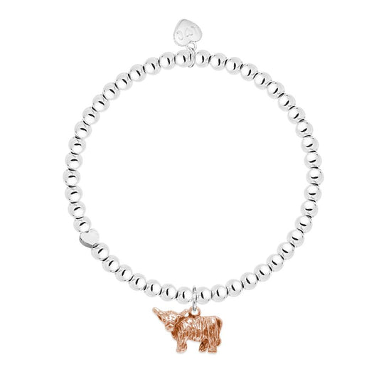 A rose gold plated highland cow charm on a bracelet with silver beaded stretch band.