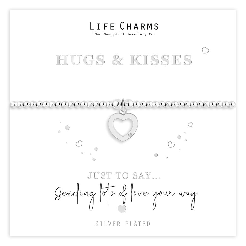 A silver-plated beaded bracelet with a heart charm, presented on a card with the message 'HUGS & KISSES' and 'SENDING LOVE YOUR WAY'. The bracelet is in a white gift box, part of a 'Life Charms' collection.