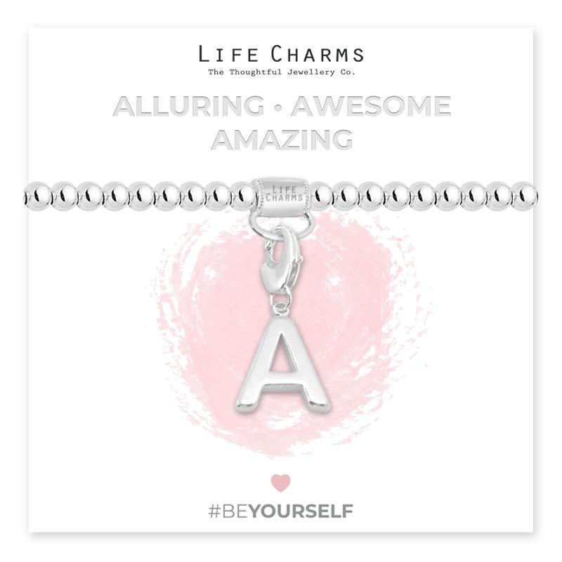 Initial charm bracelet with the letter A, presented on a silver foiled card with the text 'ALLURING • AWESOME • AMAZING' and the brand name 'LIFE CHARMS'. The bracelet is silver, and the card has a pink background with a heart shape.