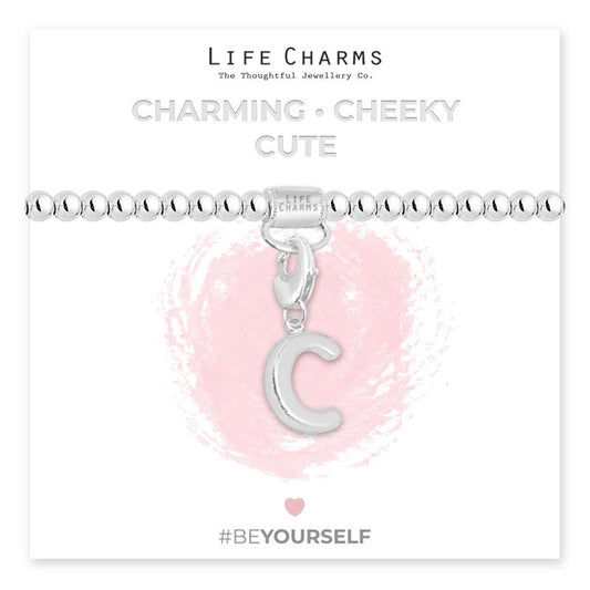 Initial charm bracelet with the letter C, presented on a silver foiled card with the text 'CHARMING • CHEEKY • CUTE' and the brand name 'LIFE CHARMS'. The bracelet is silver, and the card has a pink background with a heart shape.