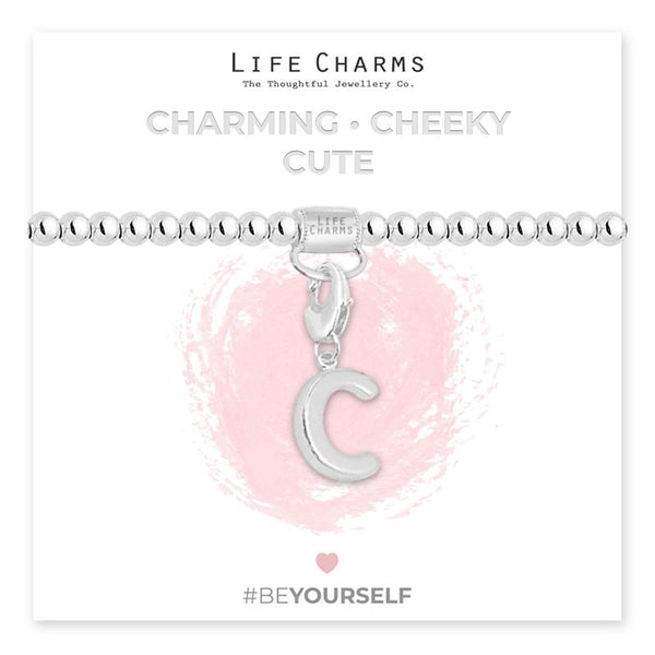 Initial charm bracelet with the letter C, presented on a silver foiled card with the text 'CHARMING • CHEEKY • CUTE' and the brand name 'LIFE CHARMS'. The bracelet is silver, and the card has a pink background with a heart shape.
