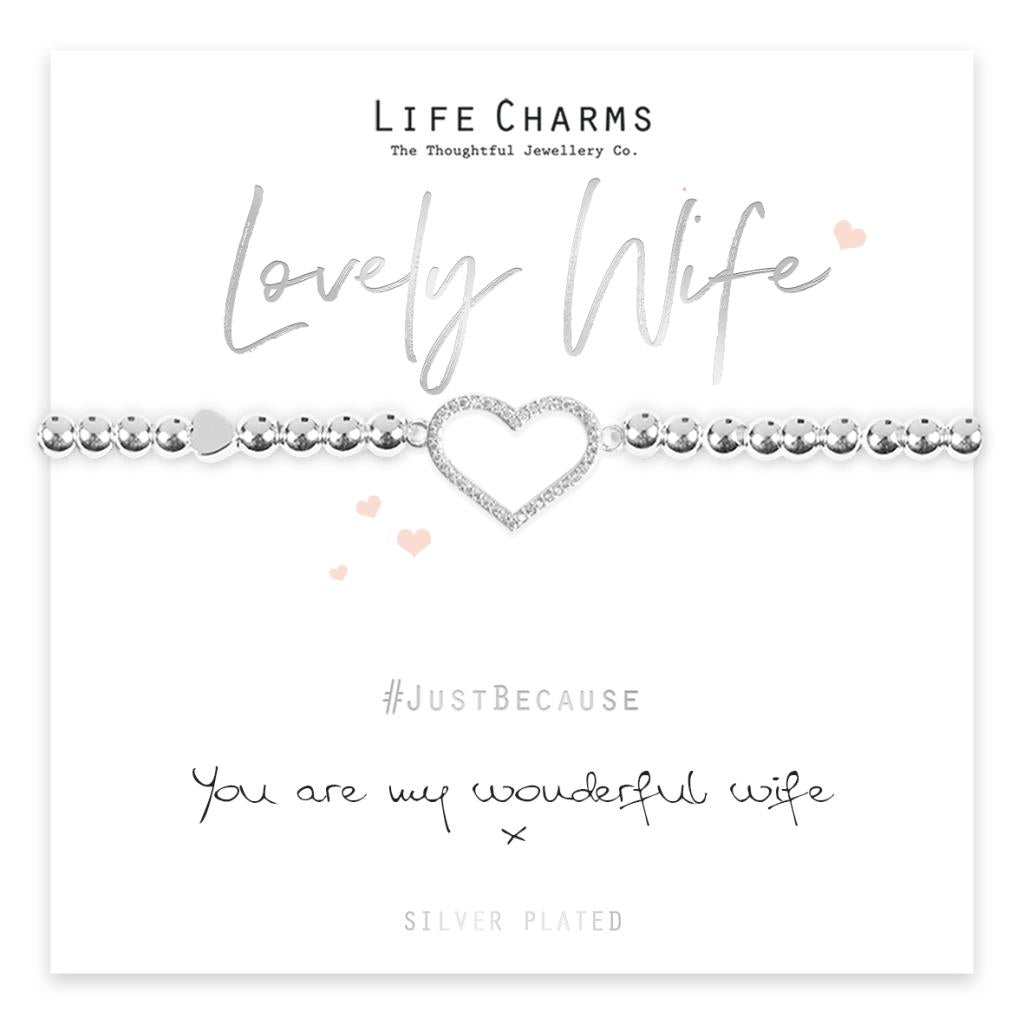 A silver-plated bracelet with a crystal encrusted heart charm, presented on a card that reads 'Lovely Wife' and 'Just Because you are my wonderful wife'. The bracelet is shown in a clear box with a white and pink decorative background.