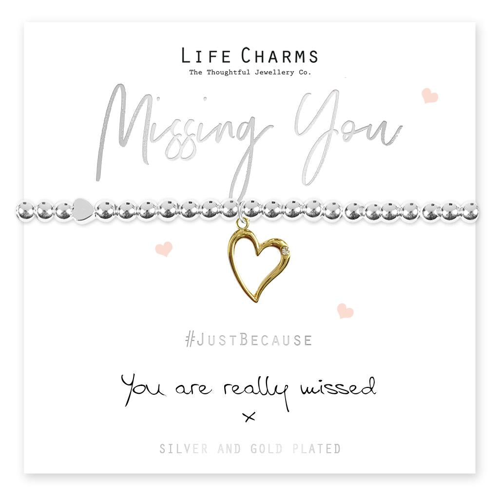 A gold-plated open heart charm bracelet with silver bead accents, presented on a card that reads 'Missing You' and 'You are really missed'. The bracelet is accompanied by a luxury gift box.