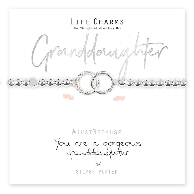 A silver-plated bracelet with a crystal encrusted circle charm, presented on a card that reads 'Granddaughter' and 'Just Because You are a gorgeous granddaughter'. The bracelet is shown with a clear crystal charm and bead details.