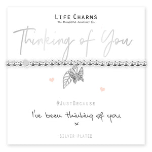 A silver beaded stretch bracelet with a star charm, presented on a card that reads 'Thinking of You' and includes a message. The bracelet is to be given as a gift and comes in a luxury gift box.